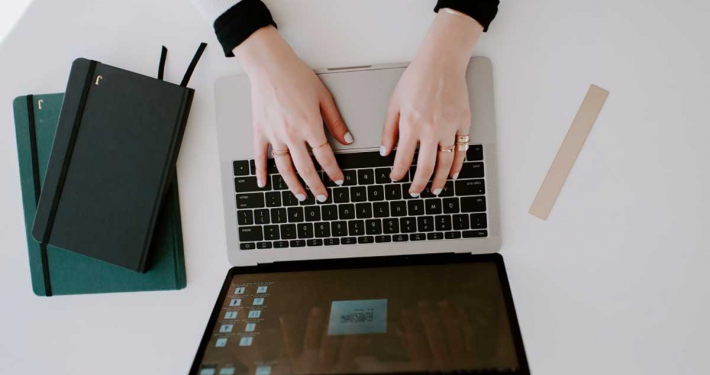 female designer typing on computer in minimal workspace