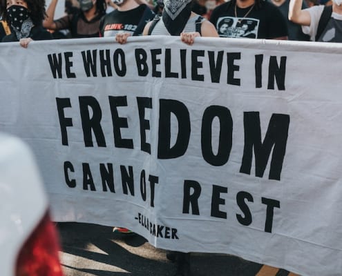 A banner that reads "We who believe in freedom cannot rest"