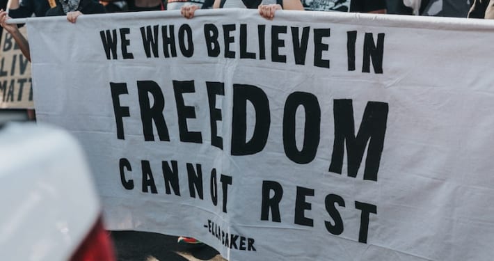 A banner that reads "We who believe in freedom cannot rest"